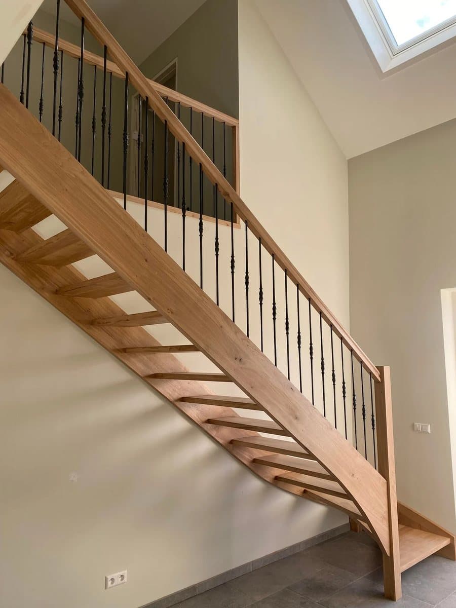 Escalier quart tournant en chêne à marches ouvertes, balustres en fer forgé noir